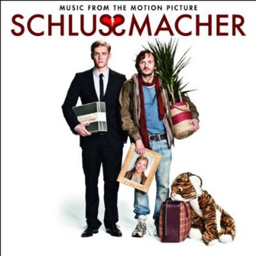 "CD cover featuring two men with luggage, a plant, and a tiger toy."