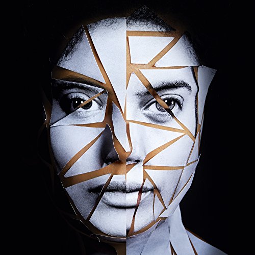 A woman's face is covered in a broken white mask with gold lines.