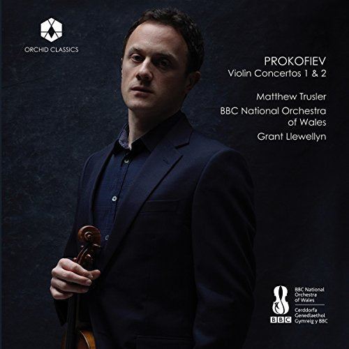 Man holding a violin, wearing a dark suit, on a dark background, with text overlay.