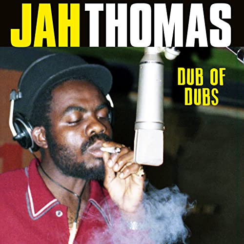 Jah Thomas in a recording studio with a microphone and smoke.