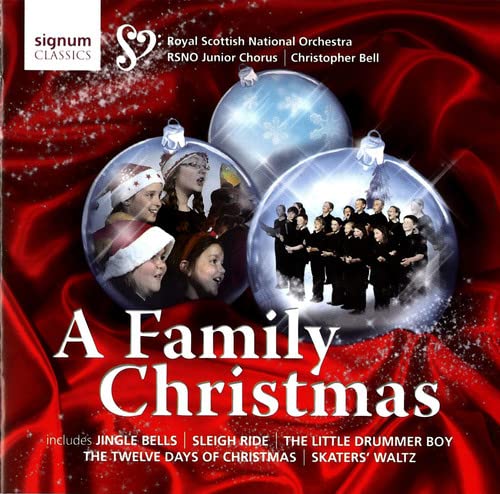 CD cover: children in ornaments, choir, and red festive background.
