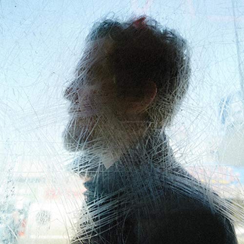 Side profile of a man seen through a scratched, translucent surface.