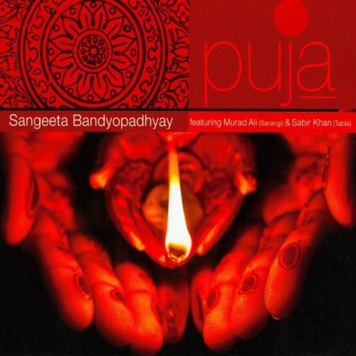 "Album cover with red background, hands holding lit diya, and intricate mandala design."