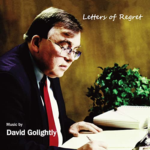 CD cover featuring a man with glasses writing at a desk.