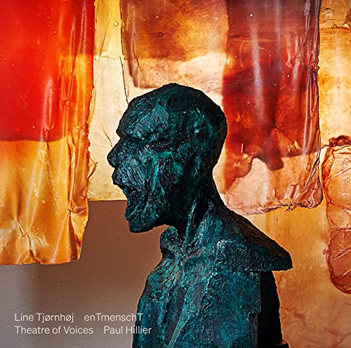 Bronze bust of a person’s head and shoulders against colorful, textured fabric.