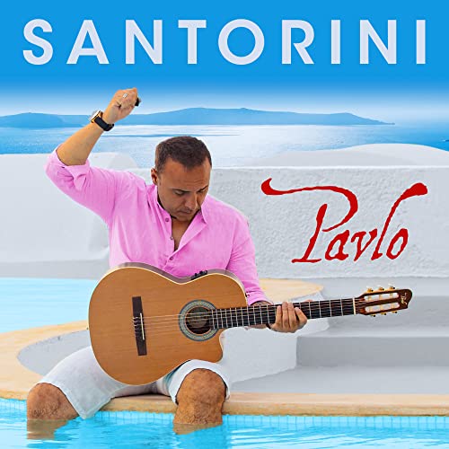 Man playing acoustic guitar by a pool, Santorini in background.