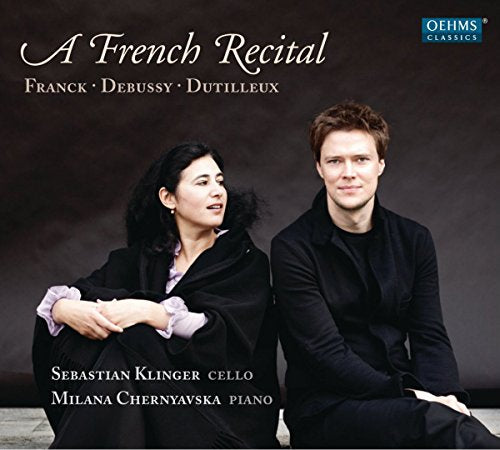CD cover featuring a man and woman sitting together, dressed in black, against a dark background.