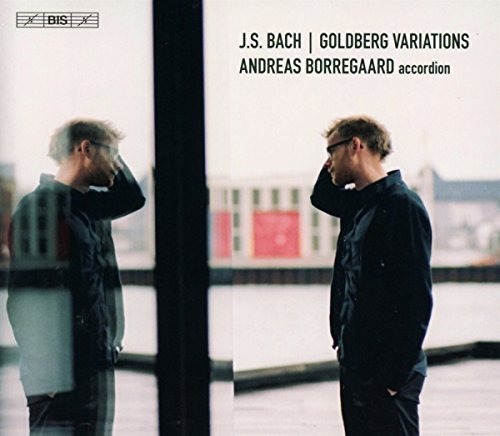 Man in black stands by window, reflected in glass, on a CD cover.