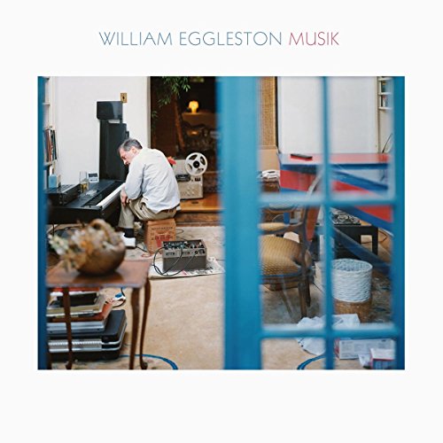 CD cover: man at piano seen through blue-barred doorway.