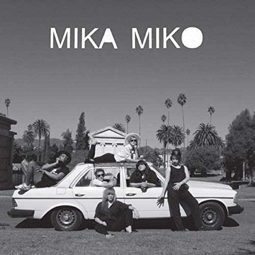 Black and white album cover featuring a band posing on a car.