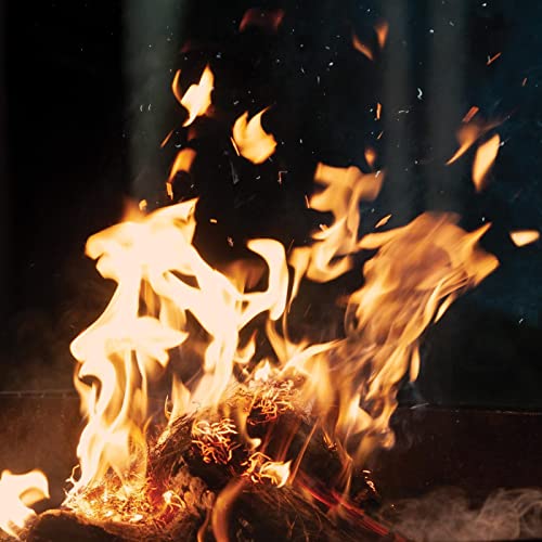 Burning embers and flames rising from a dark, smoldering fire.
