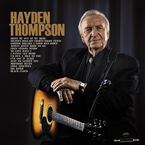 "Album cover with Hayden Thompson holding a guitar, wearing a black suit."