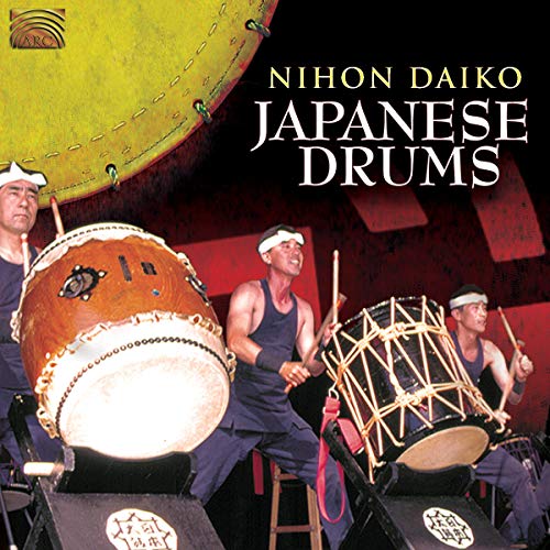 Musicians playing large Japanese taiko drums on a dark stage.