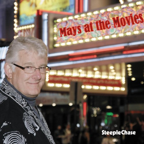 Bill Mays portrait in front of a brightly lit movie theater marquee.