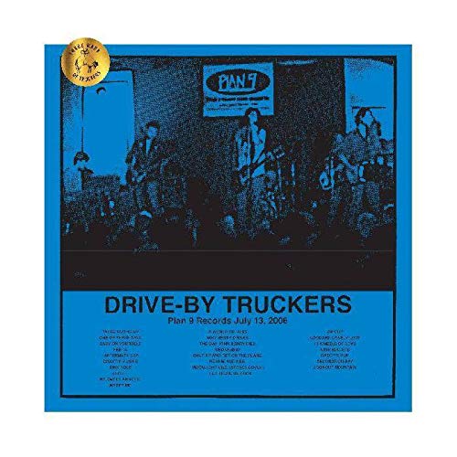 Blue vinyl album cover with band performing on stage, gold sticker in top left.
