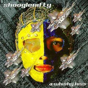 Shooglenifty album cover featuring a face split into yellow and dark halves with flowers.