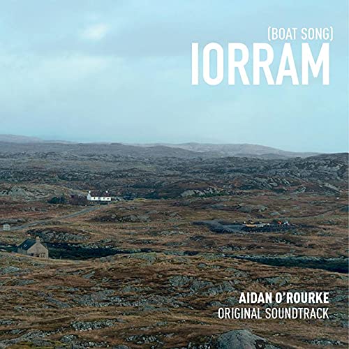 "Album cover featuring a rocky landscape with houses and white text."