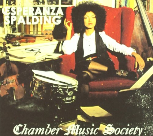 Album cover with Esperanza Spalding sitting on a red chair with musical instruments nearby.