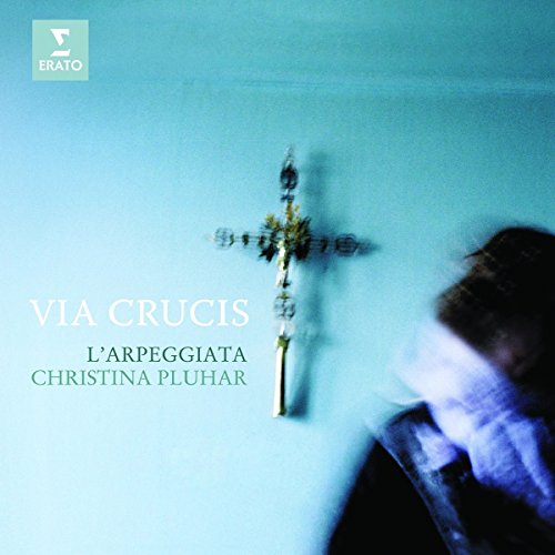 "CD cover with a blurry person and a crucifix on a blue background."
