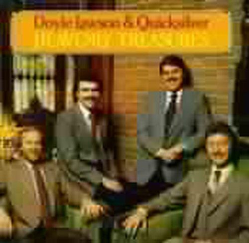 Four men in suits sit and stand outside a building, album cover artwork.