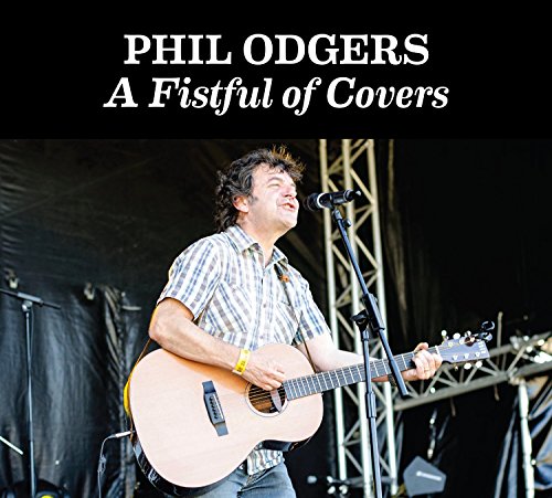 Phil Odgers performing with an acoustic guitar on stage.