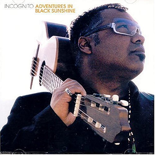 Album cover featuring a man holding a guitar, wearing sunglasses and a black shirt.
