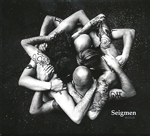 Black and white photo of tattooed people intertwined in a circular pile.