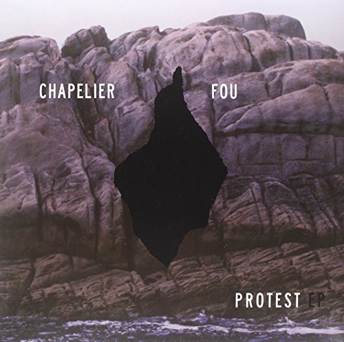 Vinyl album cover: rocky landscape with a dark, jagged cutout shape.