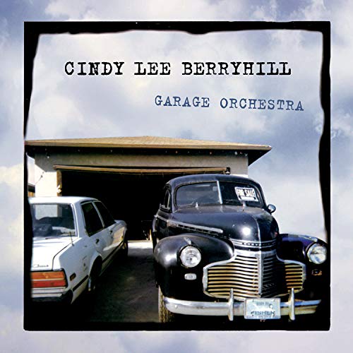 "Album cover with vintage black car and white car in a garage."