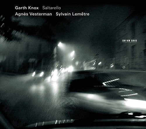 CD cover: blurred city lights seen through a rain-streaked window.