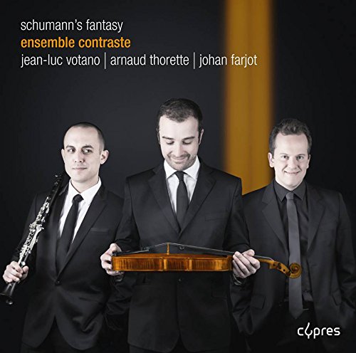 "Three men in black suits holding musical instruments against a black and gold background."