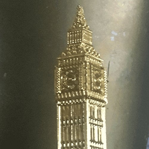 "Gold figurine of Big Ben against a dark, reflective background."