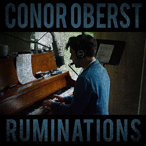 Conor Oberst at a piano with headphones in a recording studio.