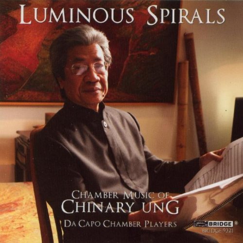 "CD cover featuring a man holding sheet music with 'Luminous Spirals' text."