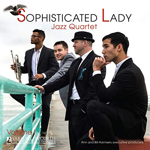 Jazz quartet in suits pose on a pier with ocean backdrop.