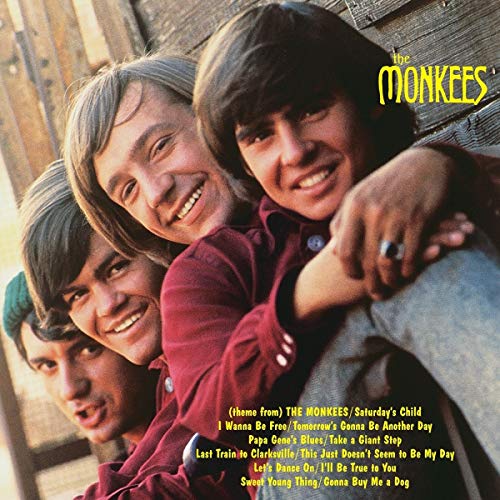 Album cover for The Monkees featuring three smiling band members.