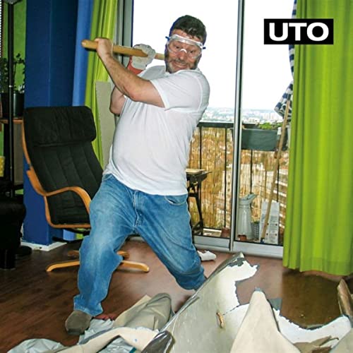 CD cover: man with axe smashing drywall indoors, wearing safety glasses.