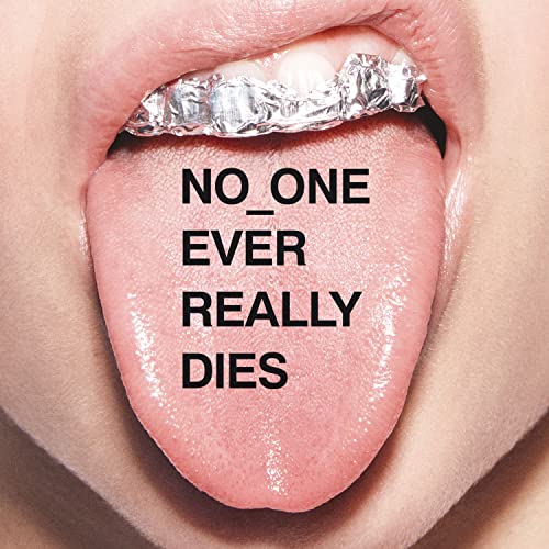 Close-up of a mouth with silver grillz and text on the tongue.