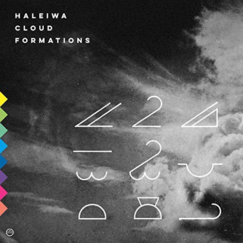"Black and white cloudy album cover with white symbols and multicolored zigzag edge."