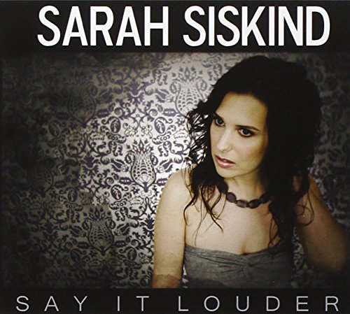 "Album cover featuring a woman with dark hair against a patterned background."
