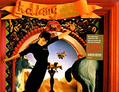 Album cover art: woman in black dress surrounded by surreal desert scene in ornate frame.