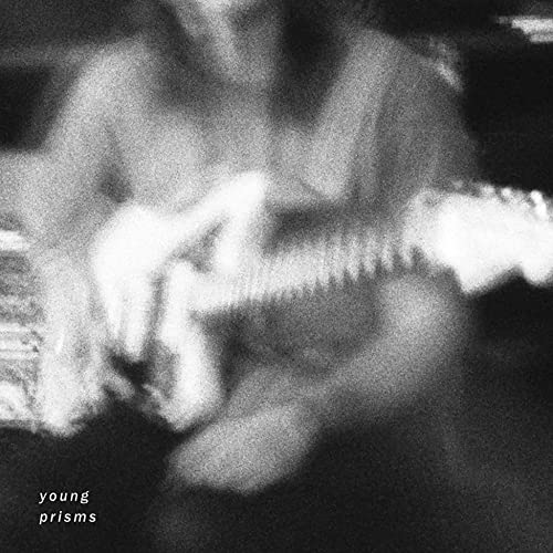 Black and white album cover with blurred figures and band name.