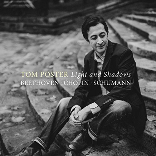 Black and white portrait of pianist Tom Poster seated on stone steps.