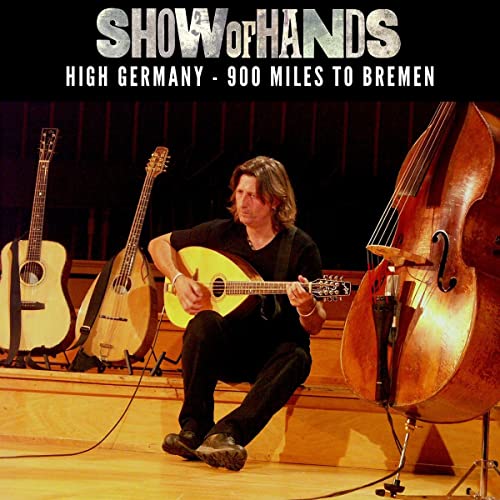 Show of Hands album cover featuring a musician with instruments.