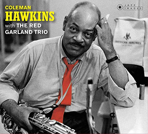 Black and white portrait of Coleman Hawkins wearing a bright red tie with saxophone.