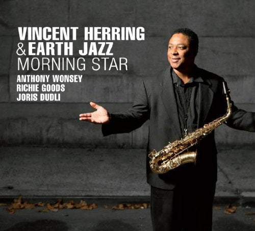 "Album cover featuring a man holding a saxophone, wearing a black suit."