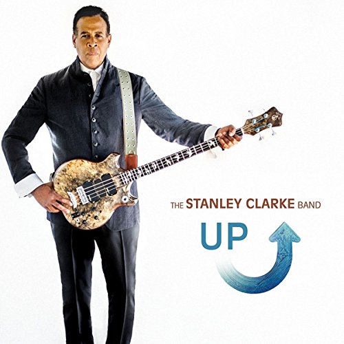 Man in suit holding bass guitar next to "The Stanley Clarke Band UP" text.