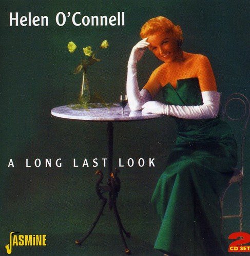 "Album cover featuring a woman in a green dress sitting at a small table."