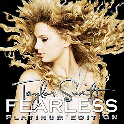 Taylor Swift with long curly blonde hair against a black background on album cover.