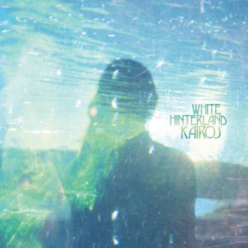 The image is a CD cover for "White Hinterland - Kairos". Alt text: A blurry image of a man with green text "White Hinterland Kairos" on the right.